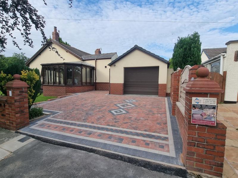 Block paved driveway with a diamond feature panel and contrasting borders to a bungalow