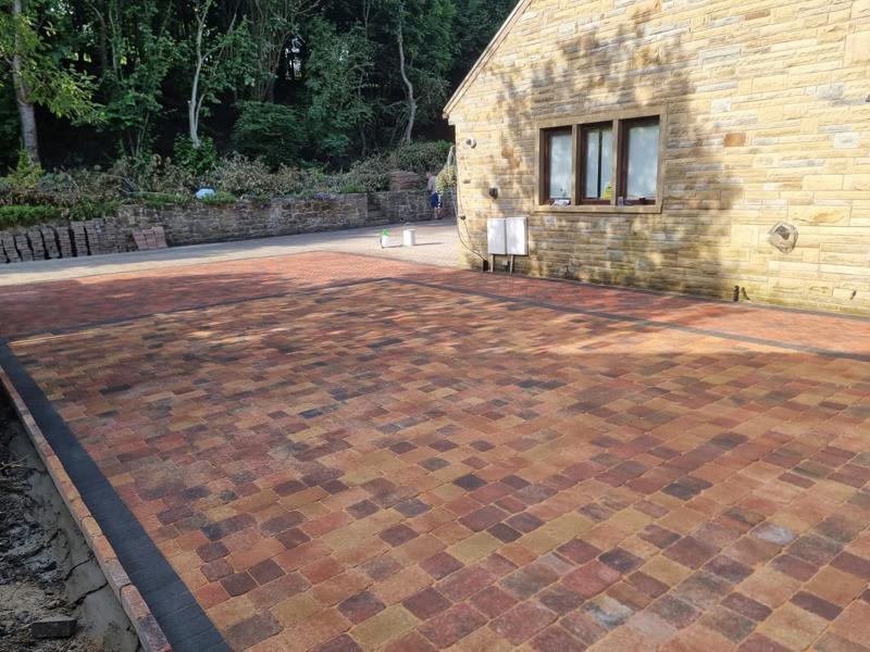 Autumn toned block paved courtyard beside a stone barn conversion